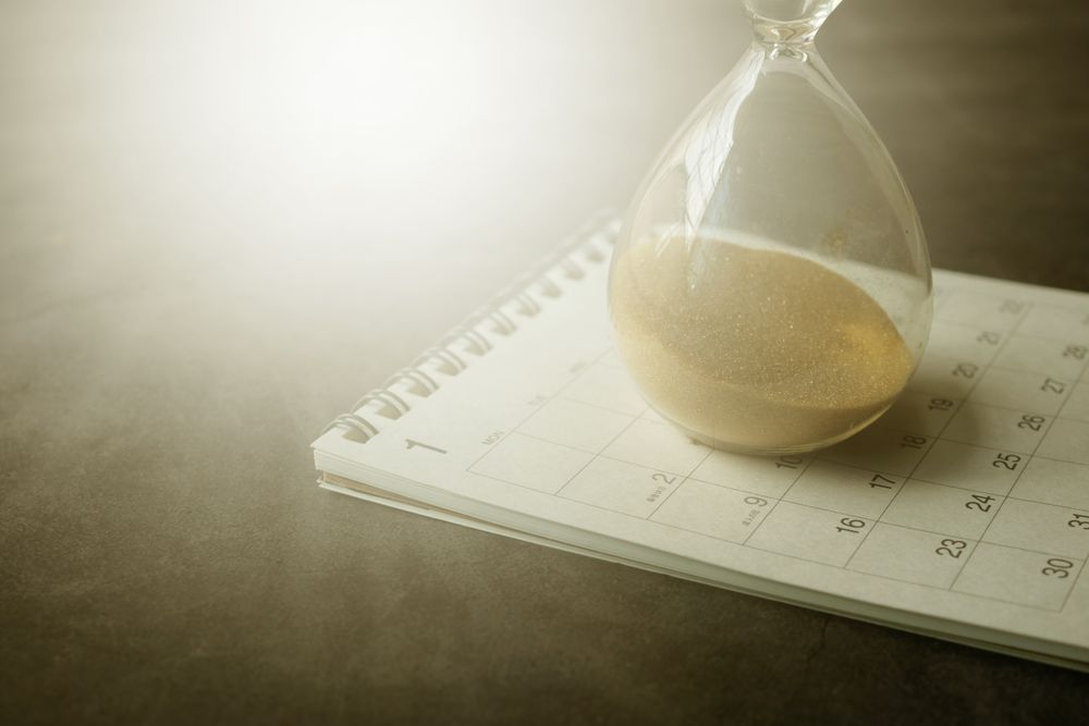 Hourglass on a calendar representing flexible scheduling